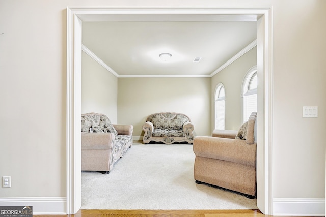 living area with ornamental molding and carpet flooring