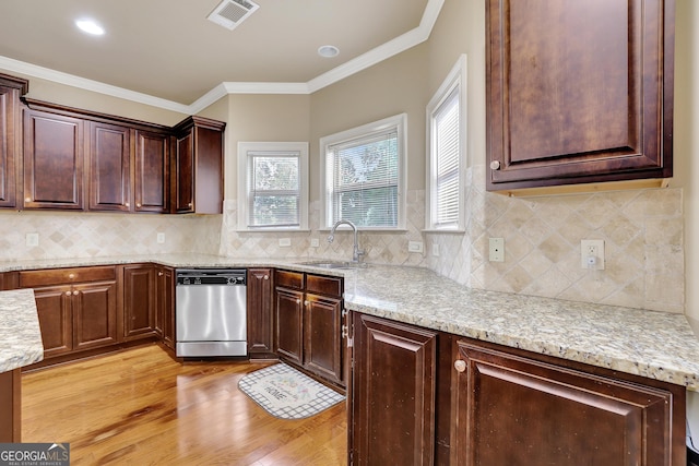 kitchen with light stone counters, dishwasher, visible vents, a sink, and light wood-style floors