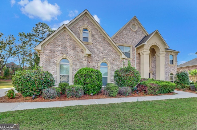 view of front of home with a front lawn and brick siding