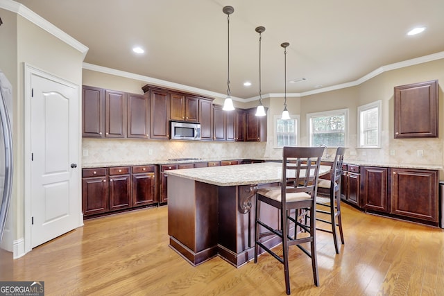 kitchen featuring backsplash, light wood-style floors, stainless steel appliances, and recessed lighting