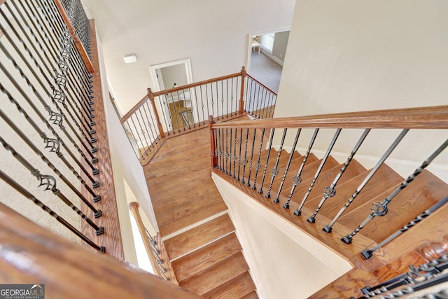 staircase featuring wood finished floors and baseboards