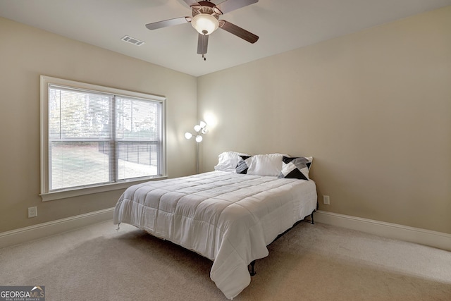carpeted bedroom featuring visible vents, baseboards, and ceiling fan