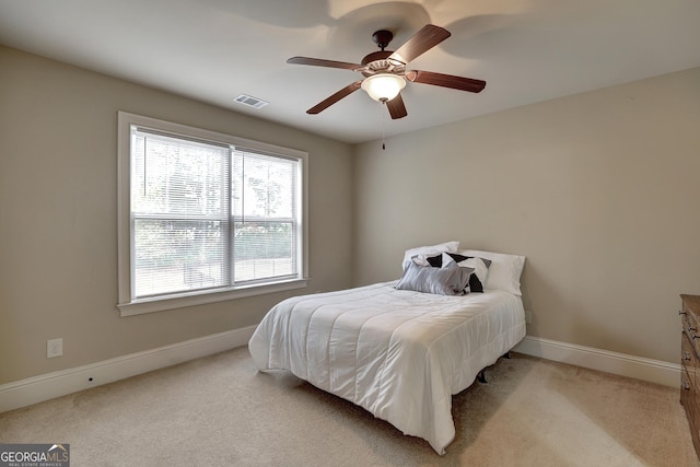 bedroom featuring baseboards, visible vents, light colored carpet, and ceiling fan