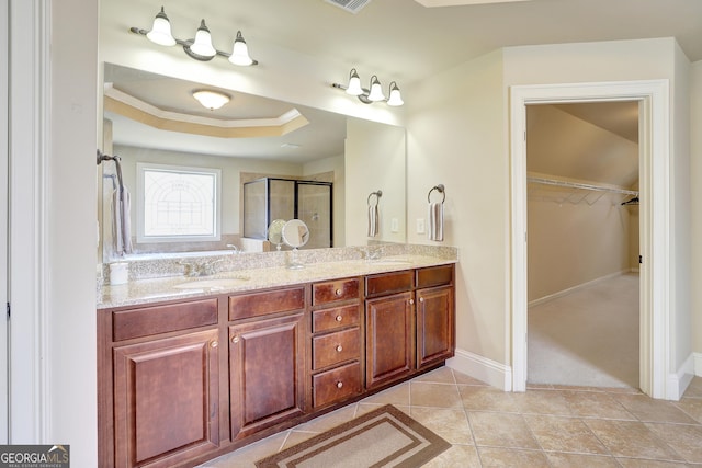 bathroom featuring tile patterned floors, a sink, double vanity, and a stall shower