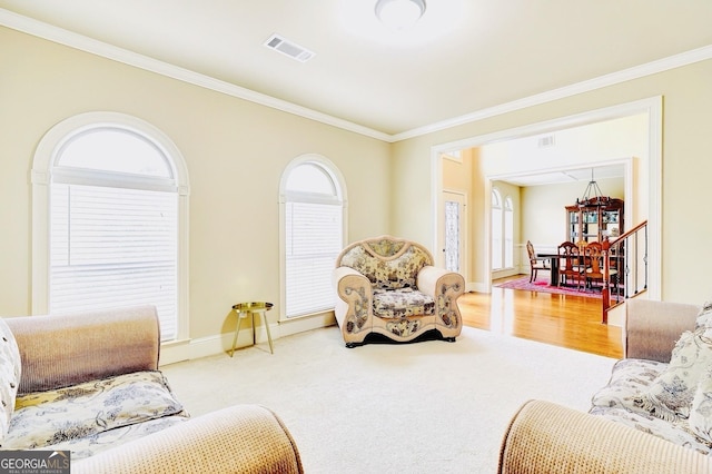 carpeted living room featuring visible vents, crown molding, and a wealth of natural light