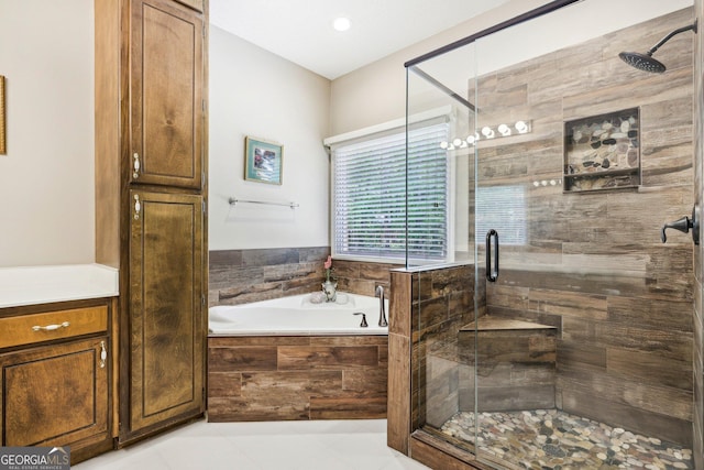 full bath featuring a shower stall, a garden tub, and tile patterned flooring