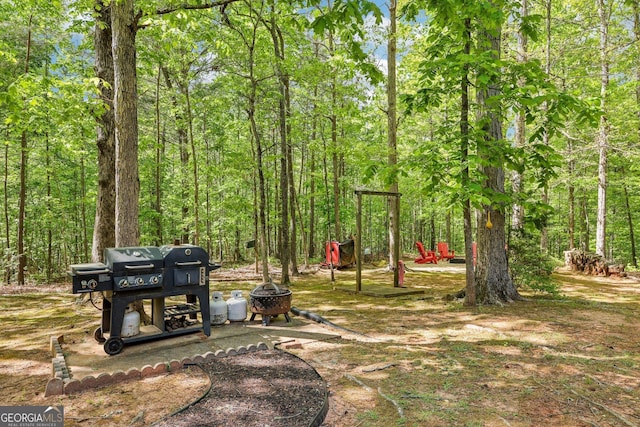 view of yard with a fire pit and a forest view