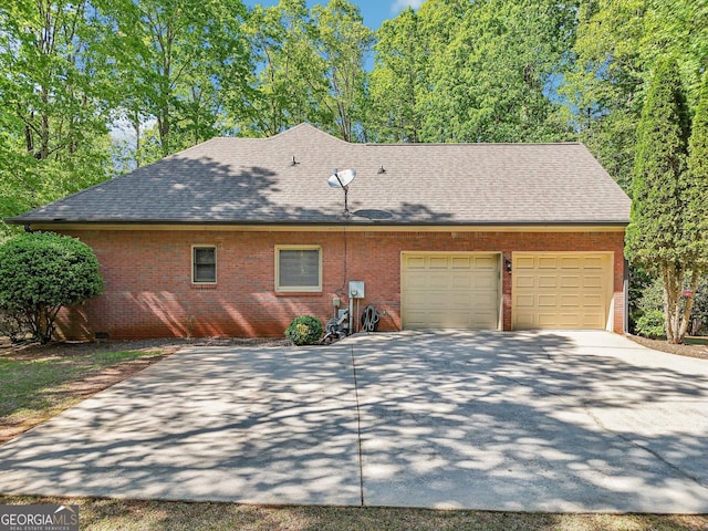 view of side of home featuring a garage, driveway, a shingled roof, and brick siding