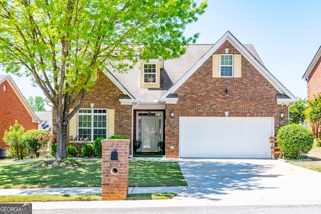 traditional-style home featuring a shingled roof, a front lawn, driveway, and brick siding
