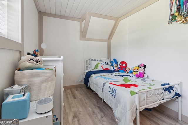 bedroom with wood ceiling, baseboards, and wood finished floors