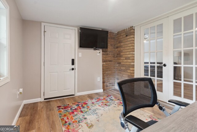 home office with baseboards, wood finished floors, and french doors