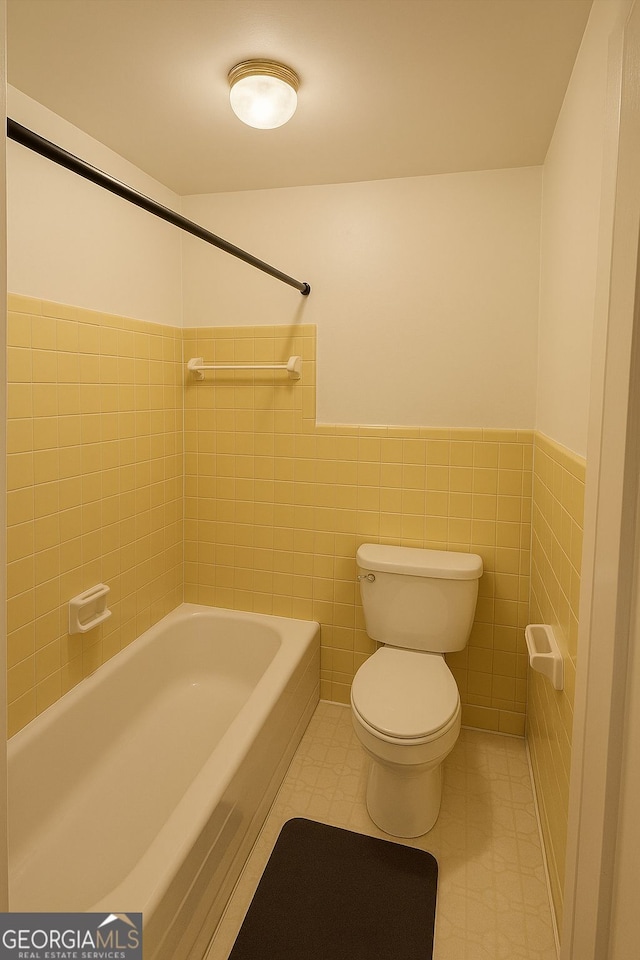 3272 Kingston Rd, Atlanta, GA 30318 - full bathroom with tile walls, tile patterned floors, a wainscoted wall, and toilet