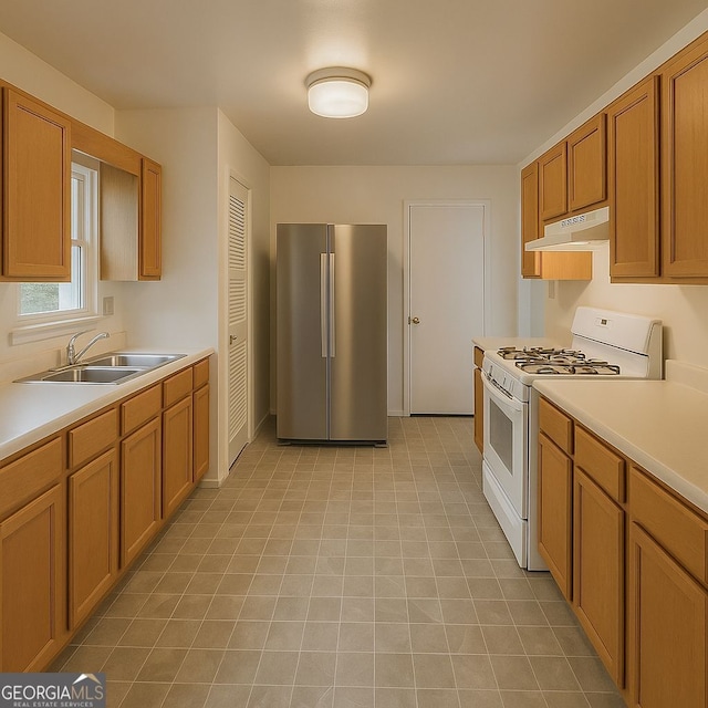 3272 Kingston Rd, Atlanta, GA 30318 - kitchen with under cabinet range hood, light countertops, a sink, white gas stove, and freestanding refrigerator