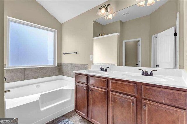 5015 Jack Dr, Decatur, GA 30035 - full bathroom with lofted ceiling, a bath, a sink, and double vanity