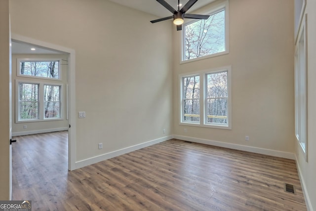 162 Forest Canopy Way, Clayton, GA 30525 - empty room featuring visible vents, a towering ceiling, wood finished floors, baseboards, and ceiling fan