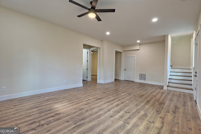 162 Forest Canopy Way, Clayton, GA 30525 - unfurnished living room featuring visible vents, stairs, wood finished floors, baseboards, and ceiling fan