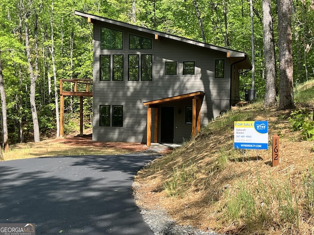 162 Forest Canopy Way, Clayton, GA 30525 - view of front of house featuring a view of trees, central AC, and a deck
