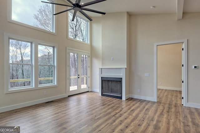 162 Forest Canopy Way, Clayton, GA 30525 - unfurnished living room with ceiling fan, a fireplace, french doors, wood finished floors, and a towering ceiling