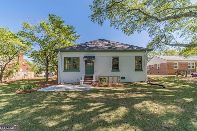 view of front of property with brick siding, a patio, and a front yard