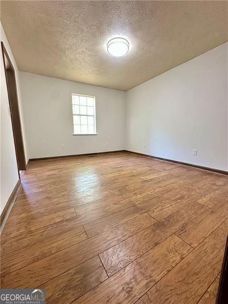 1836 Rainbow Ln, Powder Springs, GA 30127 - spare room with a textured ceiling, baseboards, and hardwood / wood-style flooring