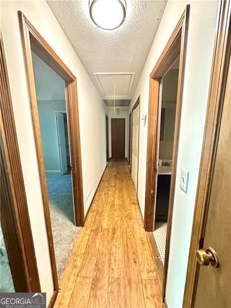 1836 Rainbow Ln, Powder Springs, GA 30127 - hall with attic access, a textured ceiling, and light wood-style flooring
