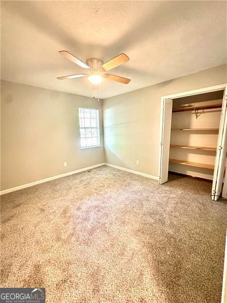 1836 Rainbow Ln, Powder Springs, GA 30127 - unfurnished bedroom featuring a closet, a textured ceiling, baseboards, ceiling fan, and carpet floors