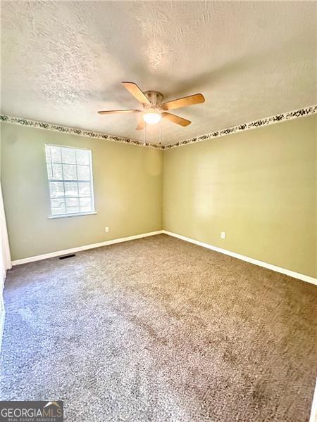 1836 Rainbow Ln, Powder Springs, GA 30127 - unfurnished room featuring baseboards, ceiling fan, and a textured ceiling