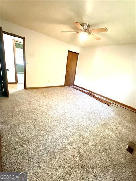 1836 Rainbow Ln, Powder Springs, GA 30127 - carpeted empty room with a ceiling fan and baseboards