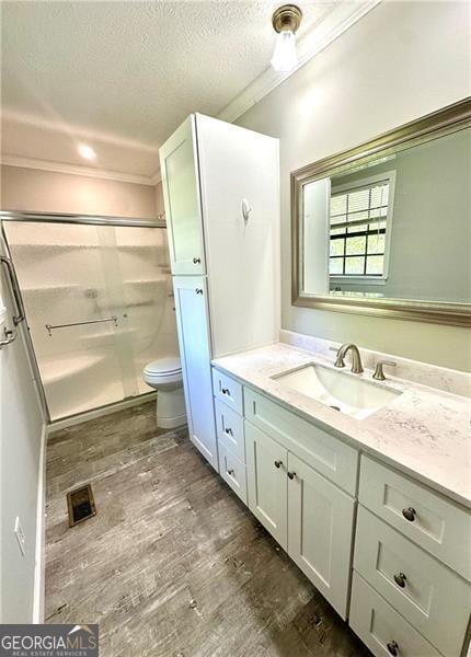 1836 Rainbow Ln, Powder Springs, GA 30127 - full bathroom featuring toilet, wood finished floors, vanity, a textured ceiling, and a stall shower