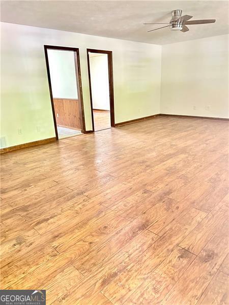 1836 Rainbow Ln, Powder Springs, GA 30127 - spare room with baseboards, hardwood / wood-style floors, and a ceiling fan