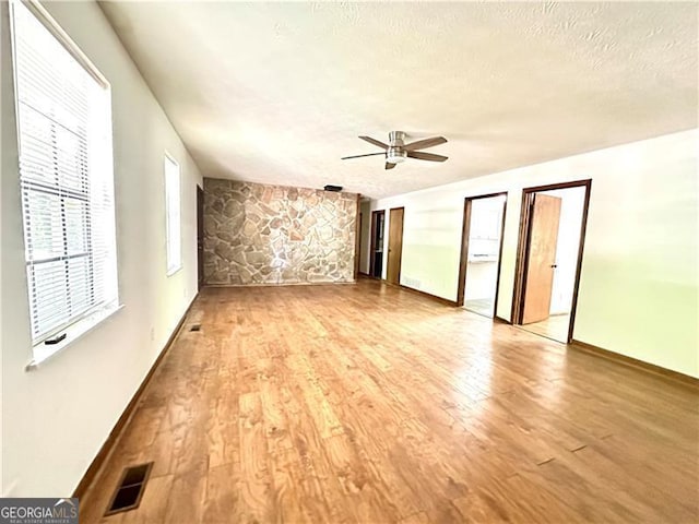1836 Rainbow Ln, Powder Springs, GA 30127 - interior space featuring a ceiling fan, light wood-type flooring, visible vents, baseboards, and a textured ceiling
