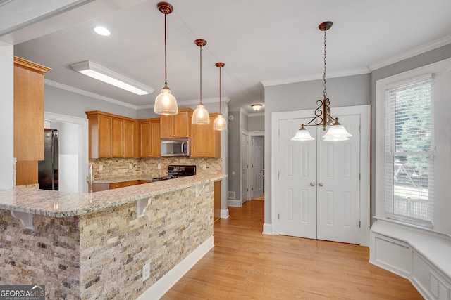 kitchen with light wood finished floors, visible vents, light stone countertops, black appliances, and tasteful backsplash