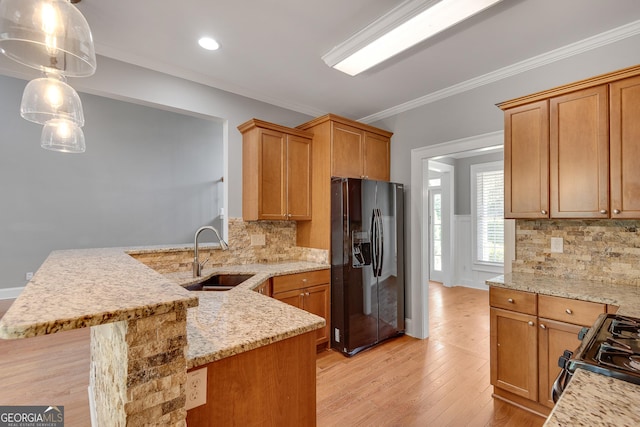 kitchen featuring a sink, light stone countertops, black appliances, a peninsula, and tasteful backsplash