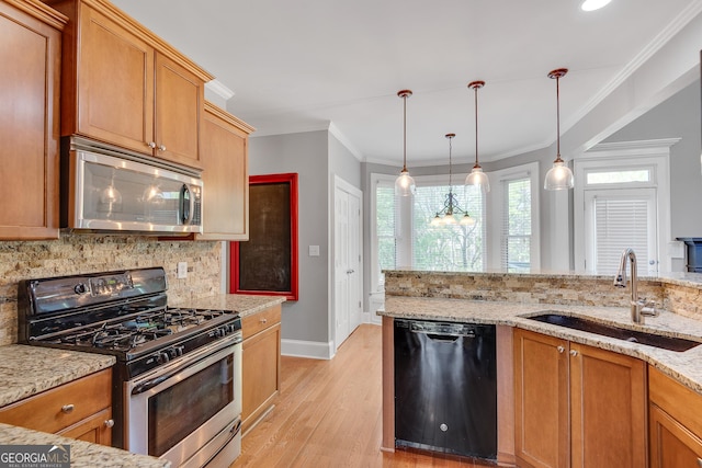kitchen featuring tasteful backsplash, a sink, a healthy amount of sunlight, stainless steel appliances, and light wood-style flooring