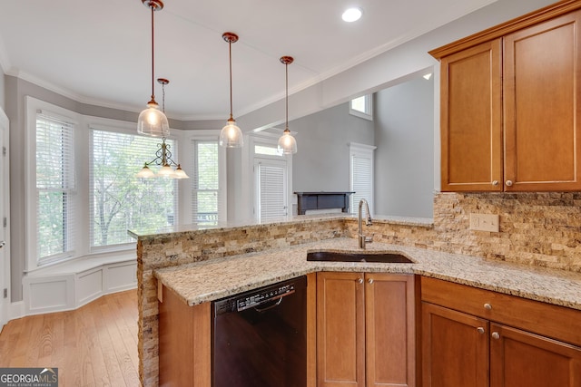 kitchen featuring brown cabinets, dishwasher, light wood-style flooring, and a sink