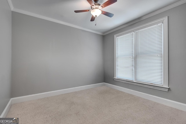 spare room with ceiling fan, baseboards, crown molding, and carpet flooring