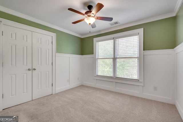 unfurnished bedroom with wainscoting, visible vents, and carpet floors