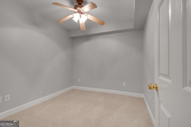 unfurnished room featuring light carpet, a ceiling fan, and baseboards