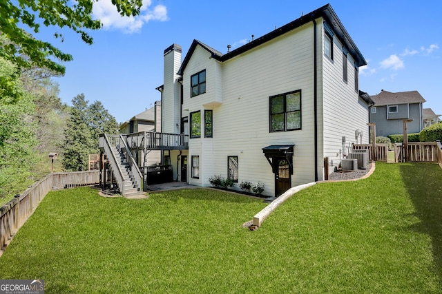 rear view of property with a lawn, a fenced backyard, stairs, and a deck