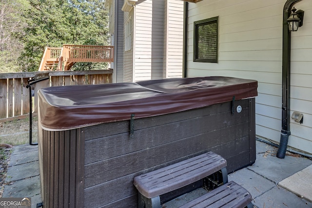 view of patio featuring fence and a hot tub