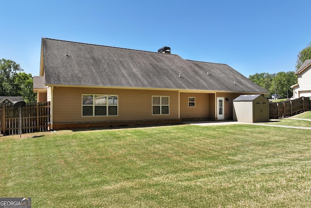rear view of property featuring fence, a shingled roof, a shed, an outdoor structure, and a patio