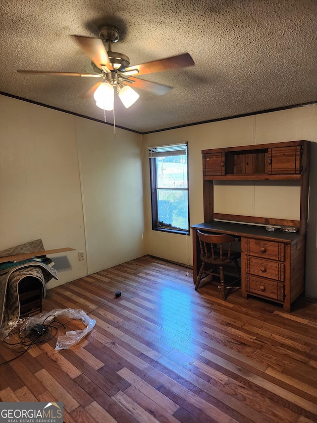 unfurnished office with dark wood finished floors, a textured ceiling, and ceiling fan
