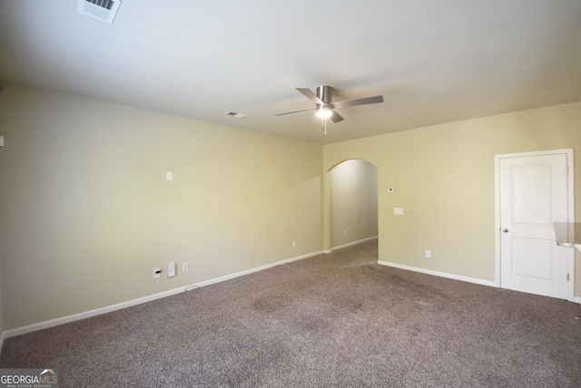 spare room featuring arched walkways, visible vents, carpet, baseboards, and a ceiling fan
