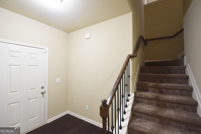 entrance foyer with dark wood-type flooring, stairway, and baseboards