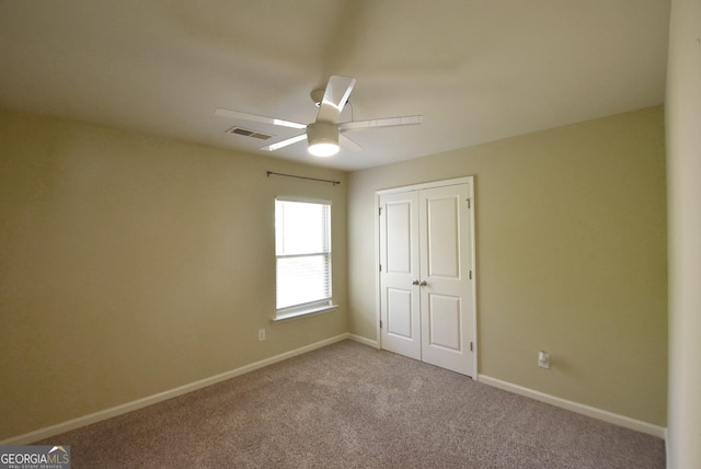 unfurnished bedroom with visible vents, carpet floors, a closet, baseboards, and ceiling fan