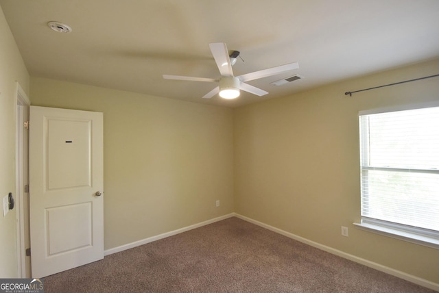 spare room featuring visible vents, carpet flooring, baseboards, and ceiling fan