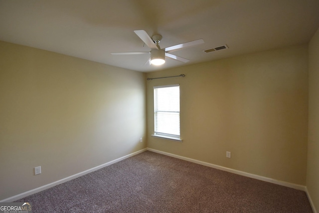 carpeted empty room with baseboards, a ceiling fan, and visible vents