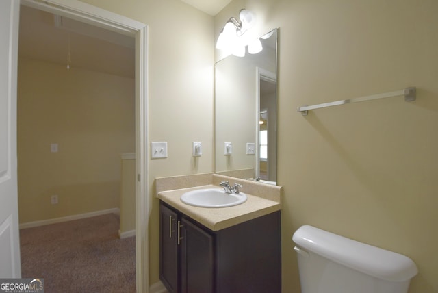 half bathroom with toilet, vanity, and baseboards