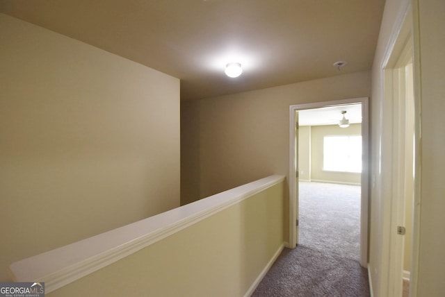 hallway with carpet floors and baseboards
