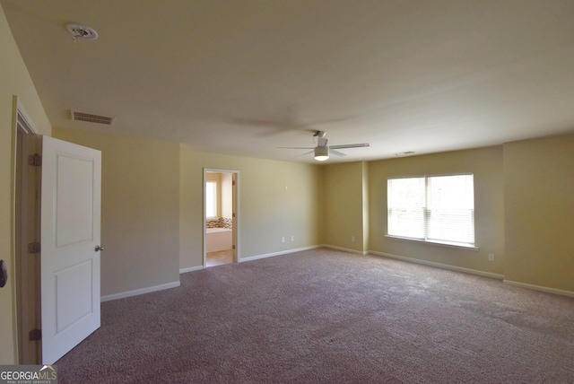 spare room with ceiling fan, carpet floors, visible vents, and baseboards